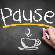 The word PAUSE written on a chalkboard with the picture of a coffee cup below